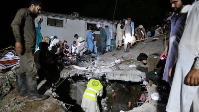 Residents and rescue workers search through the debris of this collapsed house. AFP