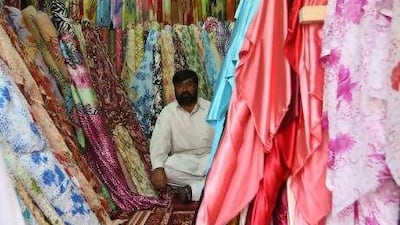 A trader plies his wares in the newly reopened Naif souk yesterday. "We saw this building destroyed by fire two years ago," said one. "It feels good to see it standing again. This souk is the heart of Dubai. "