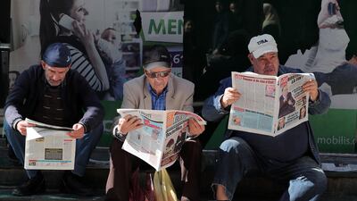 Algerian men read local newspapers a day after Algeria's President Abdelaziz Bouteflika submitted his resignation, in Algiers. EPA