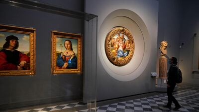 A member of the media admires 15th century painting 'Doni Tondo' by Michelangelo Buonarroti, right. AP Photo