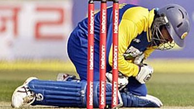 Sri Lanka's Tillakaratne Dilshan reacts in pain after he was hit by a ball because of the uneven bounce.