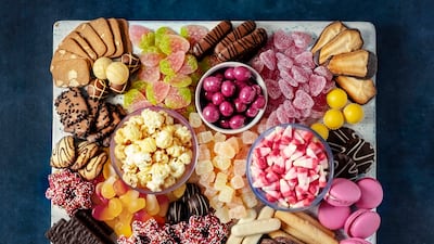 From macarons and candy to caramelised nuts, popcorn and fruit, make yours a dessert board to remember. Getty Images
