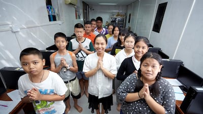 A photo of a teacher with the students who live in the community near by the Temple of Dawn attended the computer class on Sunday morning. Sasamon Rattanalangkarn for The National