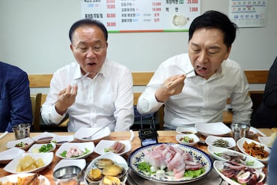 Kim Gi-hyeon (R), chief of the ruling People Power Party, and the party's floor leader, Yun Jae-ok, eat slices of raw 'mineo,' or croaker fish, for lunch at a raw fish restaurant in Incheon, west of Seoul, South Korea, on August 29, to promote sales of fish amid Japan's release of radioactive water into the ocean. EPA