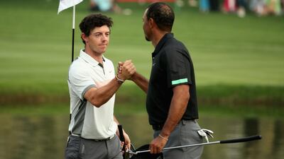 Rory McIlroy, left, and Tiger Woods shake hands on the 18th green on Friday after their second round at the Omega Dubai Desert Classic. Warren Little / Getty Images