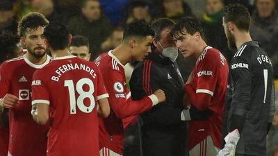 Manchester United's Cristiano Ronaldo, centre talks to Victor Lindelof, 2nd from right as receives treatment before having to leave the field during the English Premier League soccer match between Norwich City and Manchester United at Carrow road in Norwich, England, Saturday, Dec. 11, 2021. (AP Photo / Rui Vieira)