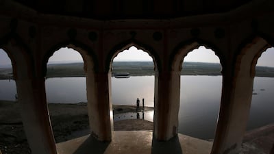 People walk on the banks of the River Ganges on the outskirts of Fatehpur, in the northern Indian state of Uttar Pradesh. AP