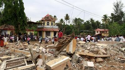 People walk past debris after a fire broke out at a temple in Kollam in the southern state of Kerala, India. A huge fire swept through a temple in India’s southern Kerala state early on Sunday, killing more than 100 people and injuring over 200 gathered for a fireworks display to mark the start of the local Hindu new year. Sivaram V / Reuters