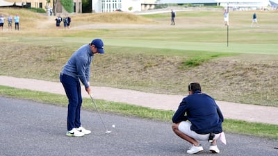 Rory McIlroy putts off a road next to the 17th green. PA