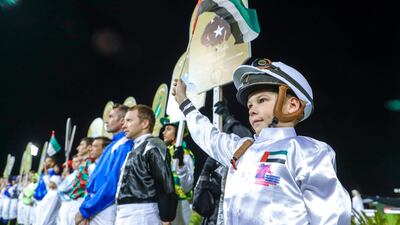 Pro and junior jockeys during the UAE National Anthem in Abu Dhabi. Victor Besa / The National