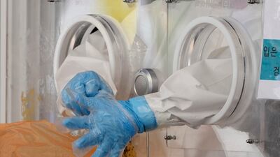 A medical worker puts on protective gloves at a coronavirus testing site in Seoul, South Korea.
