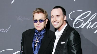 Elton John, in a black jacket with a blue splash pattern and shirt, and David Furnish arrive at a Chopard event during the 60th International Cannes Film Festival on May 25, 2007. Getty Images