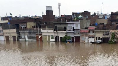 Pakistani residents wade through floodwaters following heavy rain in Lahore on September 4, 2014. More than 30 people have been killed as a result of heavy monsoon rains in Pakistan, officials said as authorities warned more intense rainfall and flash floods could be imminent. Arif Ali/AFP Photo