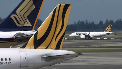 A Tiger Airways plane is towed on the runway past Singapore Airlines and Tiger Airways planes sitting on the tarmac at Changi Airport in Singapore. Reuters