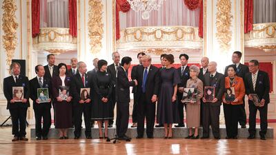 US president Donald Trump, centre, shakes hands with with Japanese prime minister Shinzo Abe next to his wife, US First Lady Melania Trump, centre right, and Japanese First Lady Akie Abe, front fifth right, during an event meeting with families who have had relatives abducted by North Korea, at Akasaka Palace in Tokyo. Trump lashed out at the US trade relationship with Japan, saying it was "not fair and open", as he prepared for formal talks with his Japanese counterpart. Jim Watson / AFP