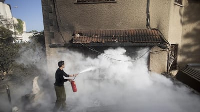 An Israeli soldier helps extinguish a fire next to a house in Haifa on November 25, 2016. Lior Mizrahi / Getty Images)