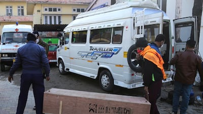 A policeman and a health worker carry the coffin of one of the victims. AP Photo