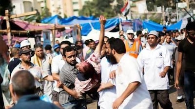 Supporters of Mohammed Morsi carry an injured man to a field hospital following clashes with security forces on Saturday morning. Manu Brabo / AP Photo
