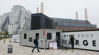 Voters arrive and leave a polling station beside Battersea Power Station in London. Reuters