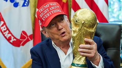 US President Donald Trump holds the Fifa World Cup Trophy on August 22. Reuters