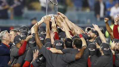 Boston Red Sox players celebrate with the Commissioner's Trophy. EPA