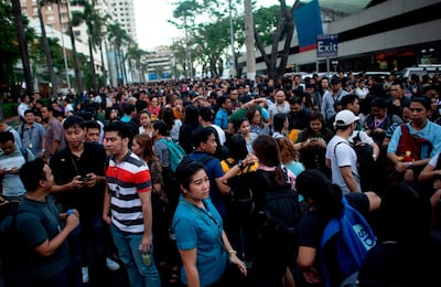 Employees are seen at an open area in Manila, after an earthquake rocked the Philippines. AFP