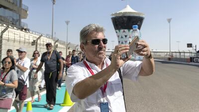 An F1 fan takes a picture during previews for the Abu Dhabi Formula One Grand Prix at Yas Marina Circuit in Abu Dhabi on November 23, 2017. Christopher Pike / The National