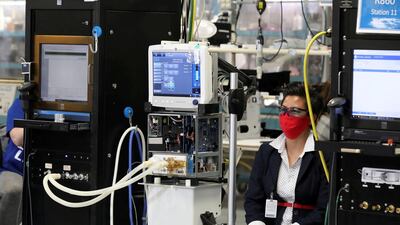 An employee wearing a face mask sits next to a GE Carescape R860 ventilator in an assembly and testing area at a GE Healthcare manufacturing facility during the global coronavirus disease (COVID-19) outbreak in Madison, Wisconsin, U.S. REUTERS