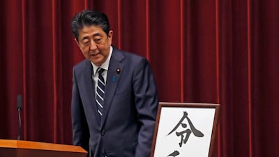 Japanese Prime Minister Shinzo Abe looks at the name of new era "Reiwa" on display at the Prime Minister's office in Tokyo. AP