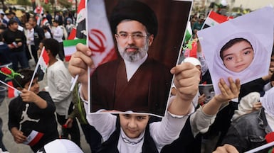 A poster of Iran's new supreme leader Mojtaba Khamenei is held up at an anti-US and Israel demonstration in Baghdad. AFP