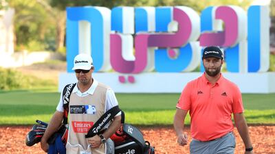 Jon Rahm with his caddie Adam Hayes walk up the 17th fairway. Getty