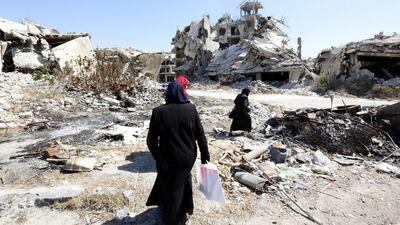 People walk between rubble in the city of Homs in Syria, where a week-long ceasefire appeared to have collapsed on September 19, 2016. Youssef Badawi / EPA /
