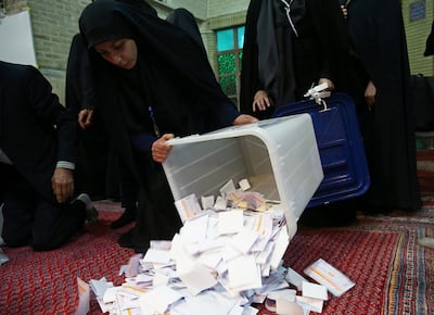 Poll workers empty full ballot boxes after the parliamentary election voting time ended in Tehran on February 22, 2020. West Asia News Agency via Reuters