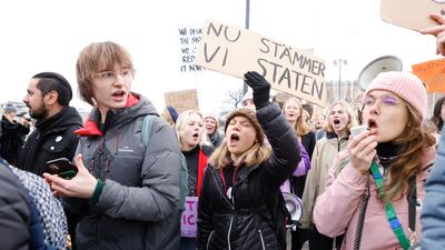 Greta Thunberg, in the black jacket, waves a placard at a climate demonstration before submitting the lawsuit. EPA