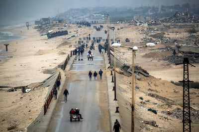 Palestinians cross the Wadi Gaza bridge and the Netzarim Corridor between Gaza city, top, and Nuseirat in central Gaza on Monday as displaced people return home during the current ceasefire. AFP