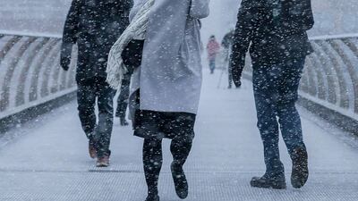 Pedestrians take a selfie crossing the millennium bridge as heavy snowfall hits London on February 27, 2018. Daniel Leal-Olivas / AFP