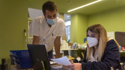 A doctor and a nurse meet at the reception of the Living Hotel before starting patient visits. Getty Images