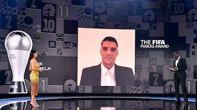 The FIFA Puskas award for 2021 winner Erik Lamela speaks with Yaya Toure, right, and presenter Reshmin Chowdhury. AP