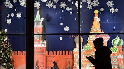 A man walks in front of a shop window decorated for the upcoming Christmas holidays in Moscow. Vasily Maximov / AFP Photo