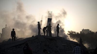 Palestinian men inspect the site of an Israeli military strike in Gaza City on Tuesday. The Israeli air force launched dozens of raids on the Gaza Strip overnight after massive rocket fire from the enclave pounded southern Israel, leaving 17 people injured, sources said. Mahmud Hams / AFP PHOTO