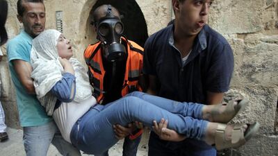 Palestinian paramedics carry a woman after Israeli security forces fired tear gas and pepper spray in a street of the Muslim quarter in Jerusalem's Old City during scuffles with Israeli riot police on September 15. AFP Photo
