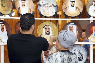 Customers peruse a stall where hand painted plates are sold. Chris Whiteoak / The National