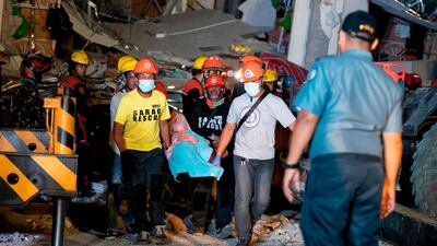 Rescue workers search for survivors in a collapsed Chuzon Super Market in Porac, Pampanga. AFP
