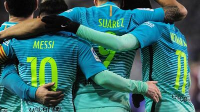 Luis Suarez celebrates with Lionel Messi and Neymar after scoring Barcelona’s third goal. Ander Gillenea / AFP