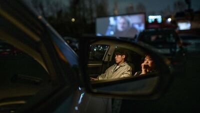A couple sit in their car as they watch a movie screening at a drive-through cinema in Seoul. AFP
