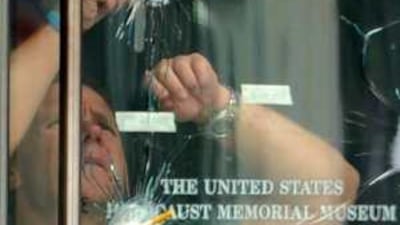 An investigator inspects bullet holes in a door at the United States Holocaust Memorial Museum in Washington, DC, on Thursday.