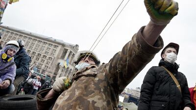 An anti-government protester uses a slingshot to throw stones towards riot police on Kiev's Independence square on February 19, 2014. Protesters braced on February 19 for a fresh assault by riot police in central Kiev after a day of clashes left at least 25 people dead in the worst violence since the start of Ukraine's three-month political crisis. As dawn rose over Kiev's battered city centre, protesters hurled paving stones and Molotov cocktails at lines of riot police that had pushed into the heart of the devastated protest camp on Independence Square. AFP PHOTO / PIERO QUARANTA