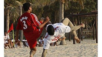 Alamabla Bakhit, of UAE team, right, tries an overhead kick as Mahammad Zaig of Oman does his best to put him off during their friendly at Al Mamzar beach in Dubai.