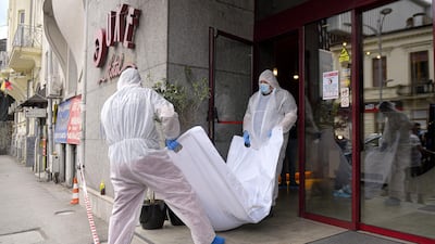 Forensic workers carry the body of Gholamreza Mansouri from a hotel downtown in Bucharest. AP