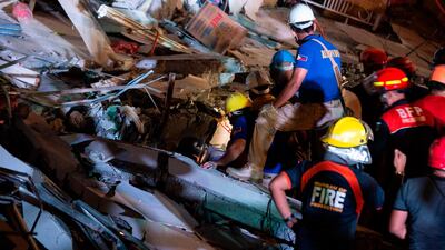 Rescue workers search for survivors in a collapsed Chuzon Super Market in Porac, Pampanga. AFP